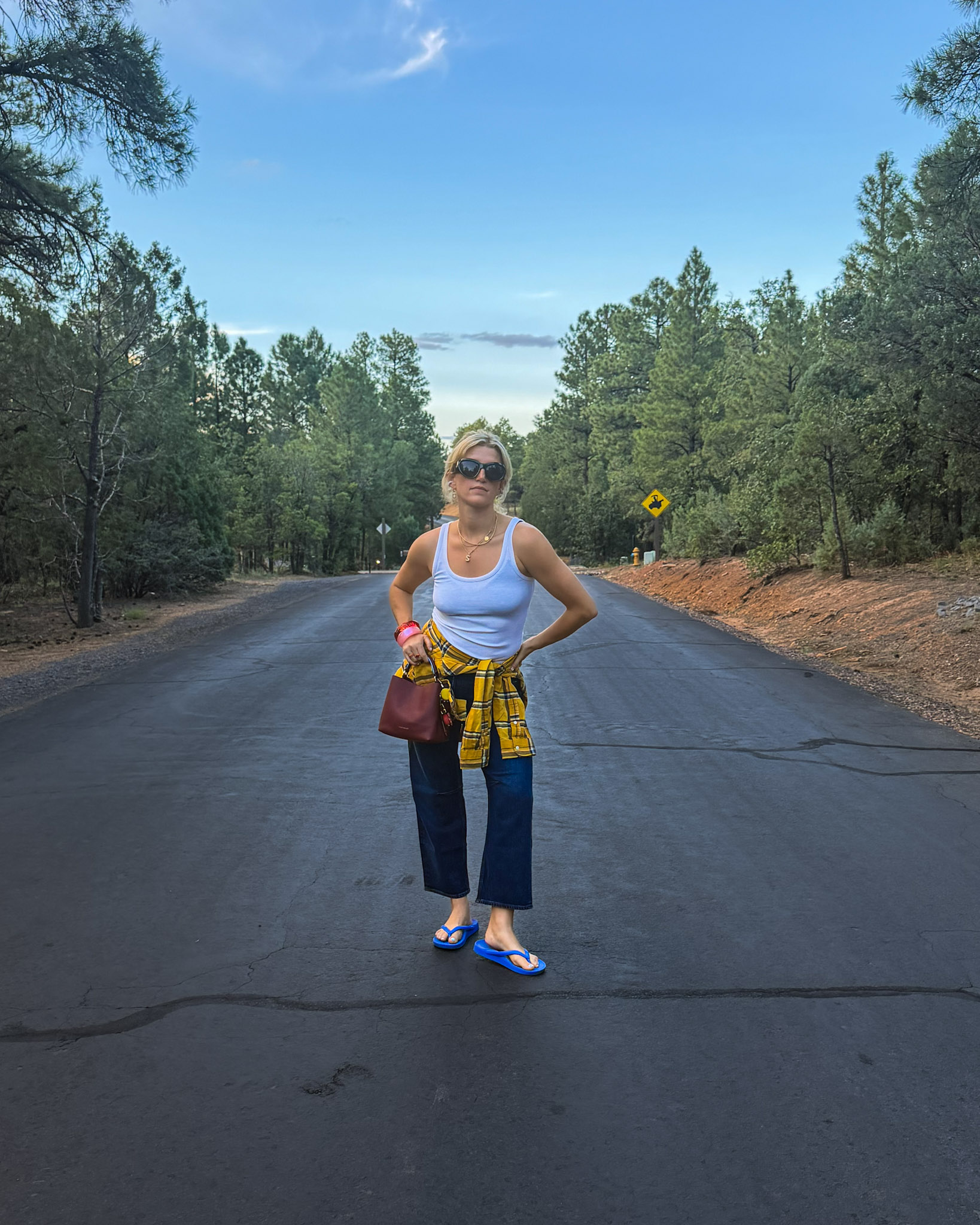 White tank, yellow plaid shirt tied at the waist, cropped denim, blue flip-flops